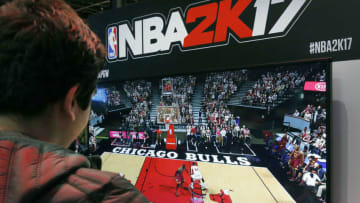 PARIS, FRANCE - OCTOBER 27: A visitor plays the video game 'NBA 2K 17' developed by Visual Concepts and published by 2K Sports on Sony PlayStation game console PS4 during the 'Paris Games Week'on October 27, 2016 in Paris, France. 'Paris Games Week' is an international trade fair for video games to be held from October 27 to October 31, 2016. (Photo by Chesnot/Getty Images)