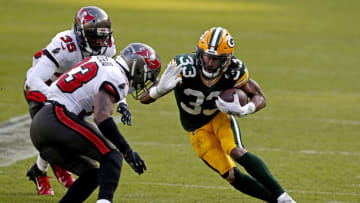 Jan 24, 2021; Green Bay, Wisconsin, USA; Green Bay Packers running back Aaron Jones (33) runs the ball against Tampa Bay Buccaneers free safety Jordan Whitehead (33) during the second quarter in the NFC Championship Game at Lambeau Field. Mandatory Credit: Jeff Hanisch-USA TODAY Sports