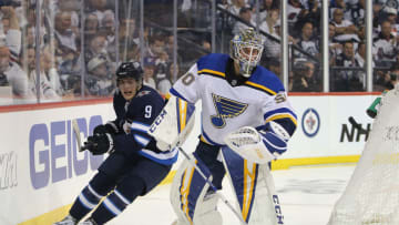 WINNIPEG, MANITOBA - APRIL 10: Andrew Copp #9 of the Winnipeg Jets chases the puck past Jordan Binnington #50 of the St. Louis Blues in Game One of the Western Conference First Round during the 2019 NHL Stanley Cup Playoffs at Bell MTS Place on April 10, 2019 in Winnipeg, Manitoba, Canada. (Photo by Jason Halstead/Getty Images)