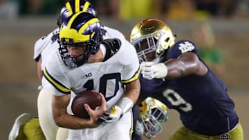 SOUTH BEND, IN - SEPTEMBER 01: Dylan McCaffrey #10 of the Michigan Wolverines tries to outrun the tackle of Daelin Hayes #9 of the Notre Dame Fighting Irish during the second half at Notre Dame Stadium on September 1, 2018 in South Bend, Indiana. Notre Dame won the game 24-17. (Photo by Gregory Shamus/Getty Images)