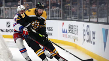 BOSTON, MASSACHUSETTS - OCTOBER 02: Will Cuylle #50 of the New York Rangers reaches for the puck against Derek Forbort #28 of the Boston Bruins during the second period of the preseason game at TD Garden on October 02, 2021 in Boston, Massachusetts. (Photo by Maddie Meyer/Getty Images)
