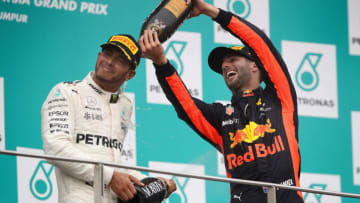 KUALA LUMPUR, MALAYSIA - OCTOBER 01: Third place finisher Daniel Ricciardo of Australia and Red Bull Racing celebrates with second place finisher Lewis Hamilton of Great Britain and Mercedes GP on the podium during the Malaysia Formula One Grand Prix at Sepang Circuit on October 1, 2017 in Kuala Lumpur, Malaysia. (Photo by Clive Mason/Getty Images)