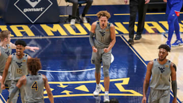 Feb 6, 2021; Morgantown, West Virginia, USA; West Virginia Mountaineers forward Emmitt Matthews Jr. (11) celebrates with teammates late in the second half against the Kansas Jayhawks at WVU Coliseum. Mandatory Credit: Ben Queen-USA TODAY Sports