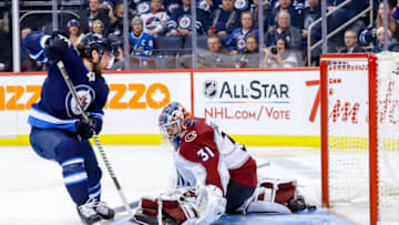 WINNIPEG, MB - JANUARY 8: Mathieu Perreault #85 of the Winnipeg Jets slips the puck underneath goaltender Philipp Grubauer #31 of the Colorado Avalanche for a first period goal at the Bell MTS Place on January 8, 2019 in Winnipeg, Manitoba, Canada. (Photo by Darcy Finley/NHLI via Getty Images)