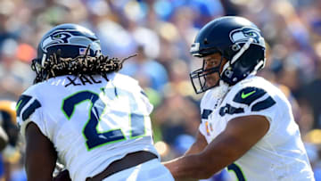 LOS ANGELES, CA - OCTOBER 08: Russell Wilson #3 of the Seattle Seahawks hands off to Eddie Lacy #27 during the game against the Los Angeles Rams at Los Angeles Memorial Coliseum on October 8, 2017 in Los Angeles, California. (Photo by Harry How/Getty Images)