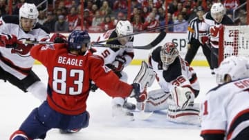 Nov 14, 2014; Washington, DC, USA; New Jersey Devils goalie Cory Schneider (35) makes a save as Devils right wing Dainius Zubrus (8) checks Washington Capitals center Jay Beagle (83) in the first period at Verizon Center. Mandatory Credit: Geoff Burke-USA TODAY Sports