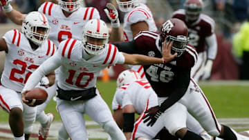 COLLEGE STATION, TEXAS - NOVEMBER 10: Jordan Ta'amu #10 of the Mississippi Rebels gives Landis Durham #46 of the Texas A&M Aggies a stiff arm as fends off a sack in the first quarter at Kyle Field on November 10, 2018 in College Station, Texas. (Photo by Bob Levey/Getty Images)