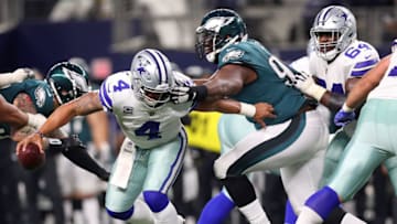 ARLINGTON, TX - NOVEMBER 19: Dak Prescott #4 of the Dallas Cowboys gets his facemask grabbed by Fletcher Cox #91 of the Philadelphia Eagles in the fourth quarter of a football game at AT&T Stadium on November 19, 2017 in Arlington, Texas. (Photo by Tom Pennington/Getty Images)