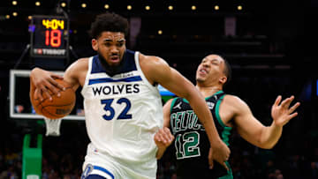 Mar 27, 2022; Boston, Massachusetts, USA; Minnesota Timberwolves center Karl-Anthony Towns (32) drives past Boston Celtics forward Grant Williams (12) during the first quarter at TD Garden. Mandatory Credit: Winslow Townson-USA TODAY Sports