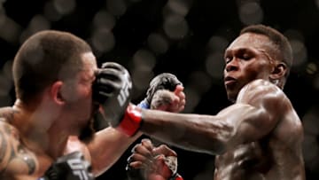 HOUSTON, TEXAS - FEBRUARY 12: Israel Adesanya of Nigeria punches Robert Whittaker of Australia in their middleweight championship fight during UFC 271 at Toyota Center on February 12, 2022 in Houston, Texas. (Photo by Carmen Mandato/Getty Images)