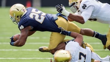 Apr 18, 2015; Notre Dame, IN, USA; Notre Dame Fighting Irish running back Tarean Folston (25) is tackled by linebacker James Onwualu (17) and linebacker Romeo Okwara (45) in the second quarter of the Blue-Gold Game at the LaBar Practice Complex. Mandatory Credit: Matt Cashore-USA TODAY Sports