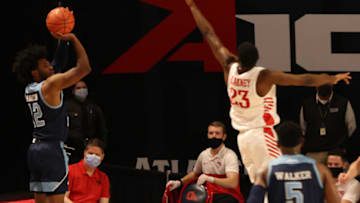 Mar 4, 2021; Richmond, Virginia, USA; Rhode Island Rams guard Malik Martin (12) shoots the ball over Dayton Flyers forward R.J. Blakney (23) in the first half in the second round of the 2021 Atlantic 10 Conference Tournament at Stuart C. Siegel Center. Mandatory Credit: Geoff Burke-USA TODAY Sports
