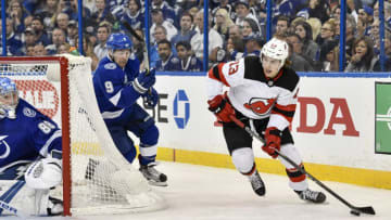 TAMPA, FL - APRIL 12: New Jersey Devils center Nico Hischier (13) looks for options as he skates away from Tampa Bay Lightning center Tyler Johnson (9) during the first period of the NHL Stanley Cup Eastern Conference Playoffs between the New Jersey Devils and the Tampa Bay Lightning on April 12, 2018, at Amalie Arena in Tampa, FL. (Photo by Roy K. Miller/Icon Sportswire via Getty Images)