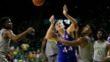 Jan 18, 2021; Waco, Texas, USA; Kansas Jayhawks forward Mitch Lightfoot (44) and Baylor Bears guard Jared Butler (12) look to grab the loose ball during the second half at Ferrell Center. Mandatory Credit: Raymond Carlin III-USA TODAY Sports