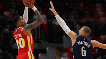 ATLANTA, GEORGIA - OCTOBER 21: John Collins #20 of the Atlanta Hawks attempts a shot against Kristaps Porzingis #6 of the Dallas Mavericks during the first half at State Farm Arena on October 21, 2021 in Atlanta, Georgia. NOTE TO USER: User expressly acknowledges and agrees that, by downloading and or using this photograph, User is consenting to the terms and conditions of the Getty Images License Agreement. (Photo by Kevin C. Cox/Getty Images)