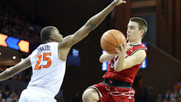 CHARLOTTESVILLE, VA - January 31: Ryan McMahon #30 of the Louisville Cardinals passes around Mamadi Diakite #25 of the Virginia Cavaliers in the first half during a game at John Paul Jones Arena on January 31, 2018 in Charlottesville, Virginia. (Photo by Ryan M. Kelly/Getty Images)