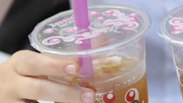 BERLIN, GERMANY - AUGUST 22: A young woman sips bubble tea outside a bubble tea cafe on August 22, 2012 in Berlin, Germany. Bubble tea, which fuses Asian tea with milk or fruit syrups and sometimes contains balls of tapioca, originated in Taiwan and has most recently spread in popularity to North America and Europe. (Photo by Sean Gallup/Getty Images)