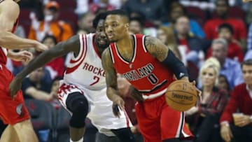 Dec 22, 2014; Houston, TX, USA; Portland Trail Blazers guard Damian Lillard (0) dribbles the ball during the first quarter as Houston Rockets guard Patrick Beverley (2) defends at Toyota Center. Mandatory Credit: Troy Taormina-USA TODAY Sports