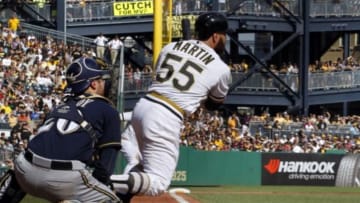Sep 21, 2014; Pittsburgh, PA, USA; Pittsburgh Pirates catcher Russell Martin (55) hits an RBI single against the Milwaukee Brewers during the seventh inning at PNC Park. Mandatory Credit: Charles LeClaire-USA TODAY Sports