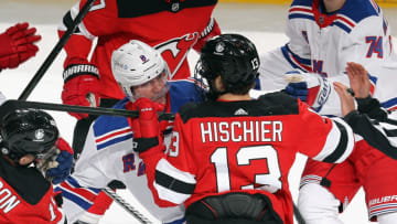 NEWARK, NEW JERSEY - APRIL 18: Nico Hischier #13 of the New Jersey Devils gets the stick up on Jacob Trouba #8 of the New York Rangers following Trouba's first period hit on Andreas Johnsson #11 (not shown) at the Prudential Center on April 18, 2021 in Newark, New Jersey. (Photo by Bruce Bennett/Getty Images)