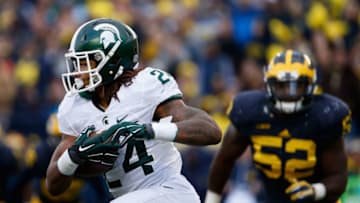 ANN ARBOR, MI - OCTOBER 17: Running back Gerald Holmes #24 of the Michigan State Spartans rushes the football past linebacker Royce Jenkins-Stone #52 of the Michigan Wolverines during the college football game at Michigan Stadium on October 17, 2015 in Ann Arbor, Michigan. The Spartans defeated the Wolverines 27-23. (Photo by Christian Petersen/Getty Images)