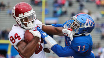 Oct 5, 2019; Lawrence, KS, USA; Oklahoma Sooners wide receiver Lee Morris (84) is knocked out of bounds by Kansas Jayhawks safety Mike Lee (11) during the first half at David Booth Kansas Memorial Stadium. Mandatory Credit: Jay Biggerstaff-USA TODAY Sports