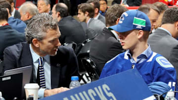 CHICAGO, IL - JUNE 24: Elias Pettersson talks with Vancouver Canucks executives after being selected fifth overall during the 2017 NHL Draft at the United Center on June 24, 2017 in Chicago, Illinois. (Photo by Bruce Bennett/Getty Images)