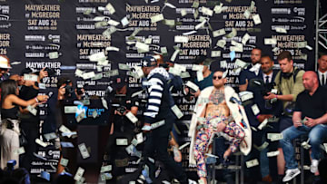 NEW YORK, NY - JULY 13: Floyd Mayweather Jr. looks on as money rains down on Conor McGregor during the Floyd Mayweather Jr. v Conor McGregor World Press Tour event at Barclays Center on July 13, 2017 in the Brooklyn borough of New York City. (Photo by Mike Stobe/Getty Images)