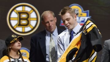Jun 26, 2015; Sunrise, FL, USA; Jake Debrusk puts on a team jersey after being selected as the number fourteen overall pick to the Boston Bruins in the first round of the 2015 NHL Draft at BB&T Center. Mandatory Credit: Steve Mitchell-USA TODAY Sports