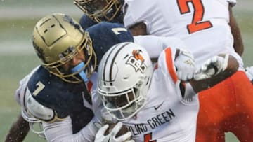 Bowling Green Falcons running back Terion Stewart (4) is brought down by Akron Zips linebacker Julian Richardson (7) and Akron Zips safety Jaylen Kelly-Powell (8) after a short gain during the second half of an NCAA football game at InfoCision Stadium, Saturday, Dec. 5, 2020, in Akron, Ohio. [Jeff Lange/Beacon Journal]Zipsfb 9