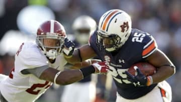 Nov 28, 2015; Auburn, AL, USA; Auburn Tigers running back Peyton Barber (25) carries the ball as he tries to avoid the tackle by Alabama Crimson Tide defensive back Geno Matias-Smith (24) in the first quarter at Jordan Hare Stadium. Mandatory Credit: John Reed-USA TODAY Sports