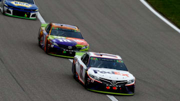 KANSAS CITY, KANSAS - OCTOBER 20: Denny Hamlin, driver of the #11 FedEx Office Toyota, leads Kyle Busch, driver of the #18 M&M's Halloween Toyota, and Chase Elliott, driver of the #9 NAPA Auto Parts Chevrolet, during the Monster Energy NASCAR Cup Series Hollywood Casino 400 at Kansas Speedway on October 20, 2019 in Kansas City, Kansas. (Photo by Jonathan Ferrey/Getty Images)