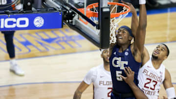 Mar 13, 2021; Greensboro, North Carolina, USA; Georgia Tech Yellow Jackets forward Moses Wright (5) dunks ahead of Florida State Seminoles guard M.J. Walker (23) during the first half in the 2021 ACC tournament championship game at Greensboro Coliseum. Mandatory Credit: Nell Redmond-USA TODAY Sports