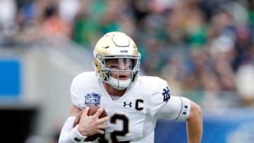 ORLANDO, FL - DECEMBER 28: Ian Book #12 of the Notre Dame Fighting Irish runs with the ball during the Camping World Bowl against the Iowa State Cyclones at Camping World Stadium on December 28, 2019 in Orlando, Florida. Notre Dame defeated Iowa State 33-9. (Photo by Joe Robbins/Getty Images)
