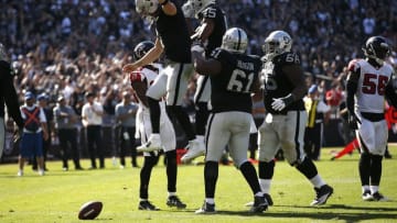 Sep 18, 2016; Oakland, CA, USA; Oakland Raiders quarterback Derek Carr (4) and wide receiver Michael Crabtree (15) react after scoring a touchdown against the Atlanta Falcons in the fourth quarter at Oakland-Alameda County Coliseum. The Falcons defeated the Raiders 35-28. Mandatory Credit: Cary Edmondson-USA TODAY Sports