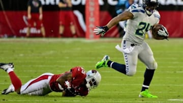 Oct 17, 2013; Phoenix, AZ, USA; Seattle Seahawks running back Marshawn Lynch (24) breaks a tackle from Arizona Cardinals cornerback Jerraud Powers (25) during the first half at University of Phoenix Stadium. Mandatory Credit: Matt Kartozian-USA TODAY Sports