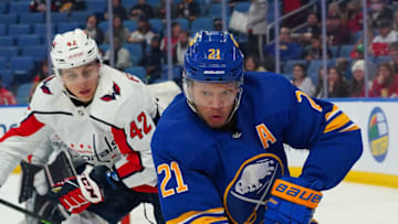 BUFFALO, NY - DECEMBER 11: Kyle Okposo #21 of the Buffalo Sabres in the corner with the puck as Martin Fehervary #42 of the Washington Capitals defends during the second period at KeyBank Center on December 11, 2021 in Buffalo, New York. (Photo by Kevin Hoffman/Getty Images)