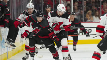 Jan 10, 2023; Raleigh, North Carolina, USA; New Jersey Devils center Yegor Sharangovich (17) and Carolina Hurricanes left wing Teuvo Teravainen (86) battle over the puck during the third period at PNC Arena. Mandatory Credit: James Guillory-USA TODAY Sports