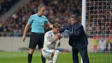 MADRID, SPAIN - NOVEMBER 18: Sergio Ramos of Real Madrid is assisted after being injured during the match between Atletico Madrid and Real Madrid as part of La Liga at Wanda Metropolitano Stadium on November 18, 2017 in Madrid, Spain. (Photo by Patricio Realpe/Getty Images)