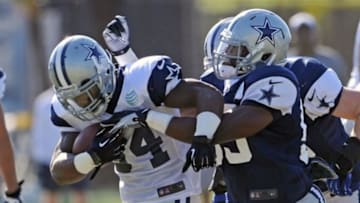 Jul 23, 2013; Oxnard, CA, USA; Dallas Cowboys inside linebacker Ernie Sims (59) stops running back Phillip Tanner (34) after a run during training camp drills at the River Ridge Fields. Mandatory Credit: Jayne Kamin-Oncea-USA TODAY Sports.