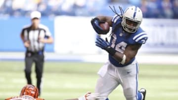 Oct 19, 2014; Indianapolis, IN, USA; Indianapolis Colts running back Trent Richardson (34) avoids a tackle by Cincinnati Bengals linebacker Marquis Flowers (53) at Lucas Oil Stadium. Mandatory Credit: Brian Spurlock-USA TODAY Sports