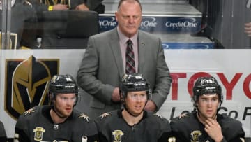 LAS VEGAS, NV - DECEMBER 14: Head coach Gerard Gallant of the Vegas Golden Knights handles bench duties behind (L-R) Jon Merrill