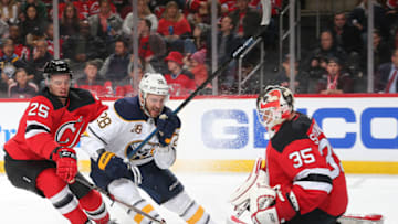 NEWARK, NJ - MARCH 25: Cory Schneider #35 of the New Jersey Devils makes a save against Zemgus Girgensons #28 of the Buffalo Sabres as he is defended by Mirco Mueller #25 of the New Jersey Devils during the second period at the Prudential Center on March 25, 2019 in Newark, New Jersey. (Photo by Andy Marlin/NHLI via Getty Images)