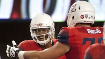 Sep 19, 2015; Tucson, AZ, USA; Arizona Wildcats quarterback Brandon Dawkins (13) and offensive lineman T.D. Gross (70) celebrate after a touchdown during the fourth quarter against the Northern Arizona Lumberjacks at Arizona Stadium. Arizona won 77-13. Mandatory Credit: Casey Sapio-USA TODAY Sports