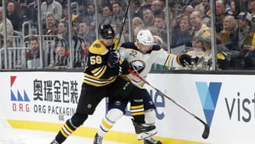 BOSTON, MA - NOVEMBER 21: Boston Bruins defenseman Urho Vaakanainen (58) checks Buffalo Sabres center Johan Larsson (22) during a game between the Boston Bruins and the Buffalo Sabres on November 21, 2019, at TD Garden in Boston, Massachusetts. (Photo by Fred Kfoury III/Icon Sportswire via Getty Images)