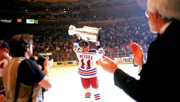 Hockey player Mark Messier of the New York Rangers lifts the Stanley Cup aloft after his team defeated the Vancouver Canucks at Madison Square Garden, New York, New York, June 14, 1994. (Photo by Bruce Bennett Studios/Getty Images)