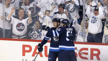 NHL DFS: WINNIPEG, MANITOBA - APRIL 20: Jacob Trouba #8 and Mark Scheifele #55 of the Winnipeg Jets celebrate Trouba's goal in Game Five of the Western Conference First Round during the 2018 NHL Stanley Cup Playoffs against the Minnesota Wild on April 20, 2018 at Bell MTS Place in Winnipeg, Manitoba, Canada. (Photo by Jason Halstead /Getty Images) *** Local Caption *** Jacob Trouba; Mark Scheifele