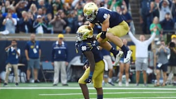 SOUTH BEND, INDIANA - SEPTEMBER 28: Cole Kmet #84 of the Notre Dame Fighting Irish celebrates after Tony Jones Jr. #6 scores a touchdown against the Virginia Cavaliers during the third quarter at Notre Dame Stadium on September 28, 2019 in South Bend, Indiana. (Photo by Stacy Revere/Getty Images)