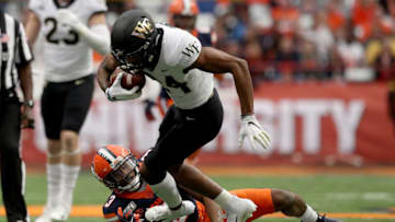 SYRACUSE, NEW YORK - NOVEMBER 30: Donavon Greene #24 of the Wake Forest Demon Deacons runs the ball as Christopher Fredrick #3 of the Syracuse Orange tackles him during the first half of an NCAA football game at the Carrier Dome on November 30, 2019 in Syracuse, New York. (Photo by Bryan M. Bennett/Getty Images)