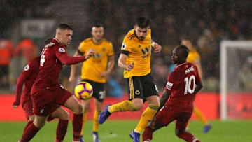 WOLVERHAMPTON, ENGLAND - DECEMBER 21: Ruben Neves of Wolves holds off pressure from Jordan Henderson (L) and Sadio Mane (R) of Liverpool during the Premier League match between Wolverhampton Wanderers and Liverpool FC at Molineux on December 22, 2018 in Wolverhampton, United Kingdom. (Photo by Richard Heathcote/Getty Images)